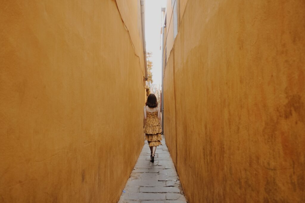 woman walking through yellow walls- coaching for women at the happy space